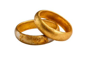 Two textured gold rings crossed on a white surface