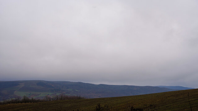 Cloudy farmland hills near Ismaily - Overcast sky above cultivated hills and distant mountains near Ismaily, Azerbaijan
