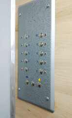 control panel in a multi-story building elevator. buttons and lights on a silver panel. ascent and descent in an elevator