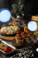 Friends enjoy a joyful feast with a variety of colorful dishes, including savory appetizers, in a beautifully decorated, warm atmosphere filled with twinkling lights