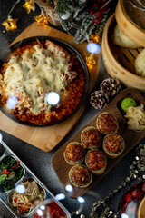 A mouthwatering spread of tasty holiday dishes fills the table, showcasing rich flavors and cozy decorations. Warm lights twinkle above as the feast invites all to indulge and celebrate together