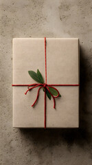 Minimalist eco-friendly Christmas gift box wrapped in kraft paper on textured background