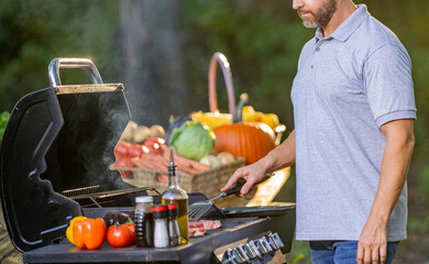 Grilling and barbecue. BBQ and grill. Man preparing beef meat in barbecue. Chef barbecuing pork steak. Backyard BBQ. Man cook meat. Man with barbeque roast meat outdoor. Meat grill rack
