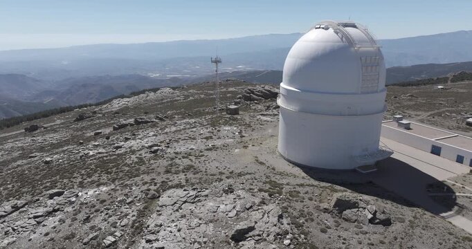 Isolated aerial drone shot of Calar Alto Observatory astronomy telescope in the Sierra de Los Filabres mountain range in Almeria, Andalusia, Spain. Largest observatory in Europe. Sunny, clear blue sky