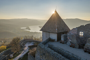 Visegrad, Hungary - Aerial panoramic drone view of the beautiful high castle of Visegrad on a moody autumn sunset. Danube Bend (Dunakanyar) and amazing golden sunset at background.