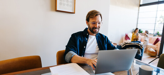 Man working from home with family in background