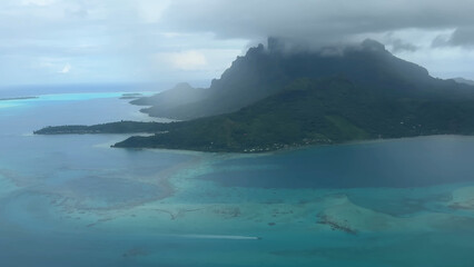 Luxury resort photo of French Polynesia tropical 
paradise island Fakarava with palm trees. Photography
with ocean, mountain, sky with clouds.
