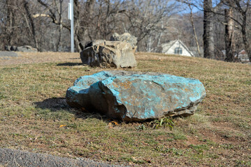 A Large Stone In A Grassy Park Environment.