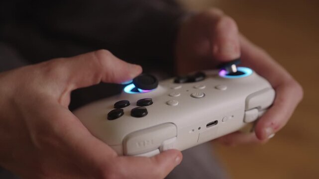 Woman with cerebral palsy finding joy in gaming at home, hands holding glowing video game controller, enjoying accessible leisure and entertainment, close-up. Concept of diversity, equity, inclusion.