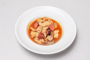 The tripe is served steaming hot on a flat plate, accompanied by its thick, spicy sauce, a traditional dish in Madrid bars, ideal for sharing on a cold morning