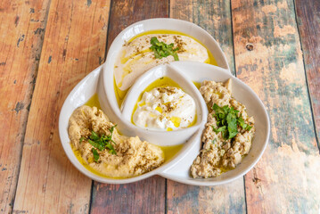 A minimalist presentation of hummus on a white plate, where the smooth, perfect chickpea cream is the sole protagonist, without any embellishments