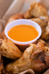 Bowl of creamy orange dipping sauce served with fried chicken wings