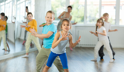 Group of children boys and girls dance energetic pair dance twist in studio