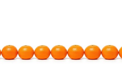 Row of fresh oranges on white background displaying bright vivid color and symmetry