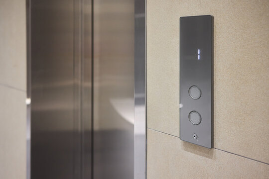 High-tech elevator panel featuring tactile buttons and illuminated screen, Advanced elevator interface showcasing touch sensitive controls alongside bright digital display screen - Powered by Adobe