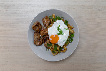 A plate of grilled chicken and fried egg.