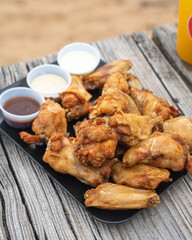 Fried chicken wings served on a platter with assorted dipping sauces
