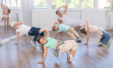Group of active children dancers having break dance training at dance studio
