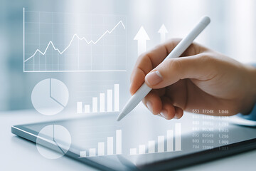 Business hand using stylus on futuristic tablet analyzing holographic charts graphs and financial metrics to track corporate growth trends