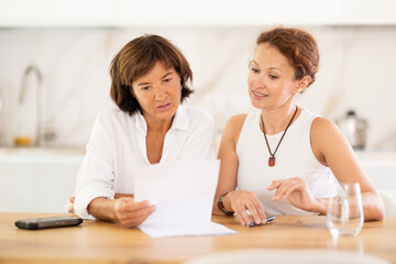 Obraz premium Woman helps her friend sort out documents and financial problems