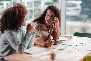 Diverse coworkers collaborating on project during meeting