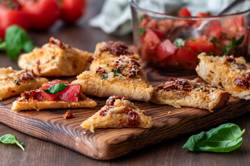 Slices of baguette with a bowl of fresh bruschetta for topping.