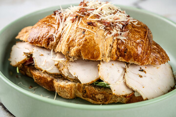 Fresh croissant sandwich with sliced turkey