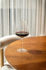 Elegant glass of red wine on wooden table