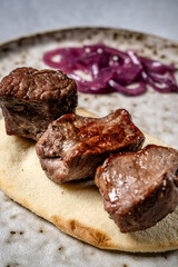 Closeup grilled beef cubes on flatbread