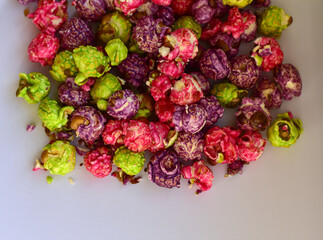 Colorful popcorn on white background. A pile Colored fruity popcorn ready to eat. Food background. Cinema concept.