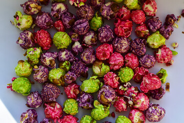 Colorful popcorn on white background. A pile Colored fruity popcorn ready to eat. Food background....