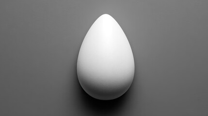 A single white egg rests on a plain gray surface.