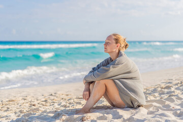 Woman enjoying peaceful time at the beach, relaxing on the sand with ocean views and warm sunlight. Summer leisure, wellbeing and travel concept, representing freedom, calmness and mindful coastal