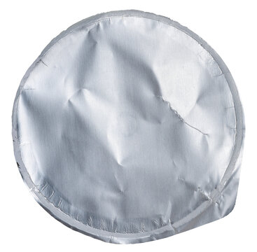 Close-up of a crumpled round foil yogurt lid on an isolated background.