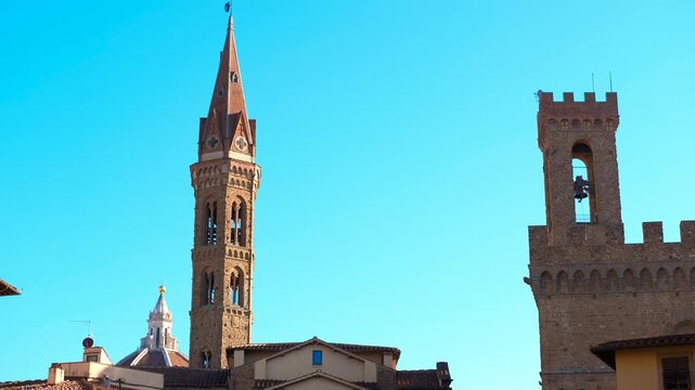 Badia fiorentina and bargello tower rising above florence skyline. Scenic panorama revealing historic badia fiorentina and bargello towers rising against bright blue sky, capturing medieval florence