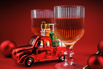 Macro view of whiskey glass with red toy car carrying wrapped Christmas presents and holiday decor