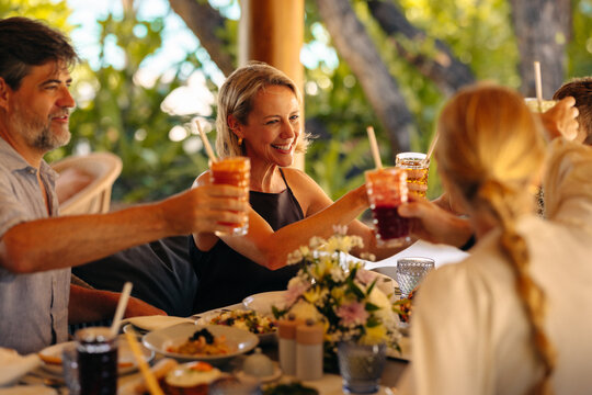 Family toasting over a festive holiday meal on an island, celebrating happiness together