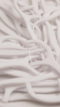 white dental floss picks, rotation in circle. oral hygiene floss tool. vertical video.