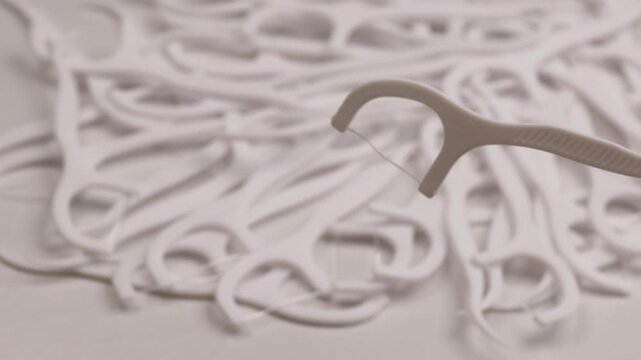 single dental floss pick, rotation in circle. one floss tool above rotating background, Turning. clean hygiene product