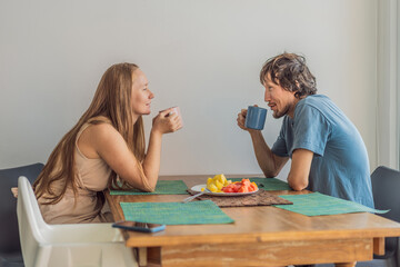 Woman and man having breakfast together at the table, enjoying a calm morning atmosphere at home. Cozy lifestyle, wellness, nutrition and togetherness concept, representing connection, routine and