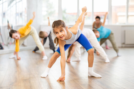 Happy smiling preteen dancers practicing dance routine with female choreographer in modern studio - Powered by Adobe