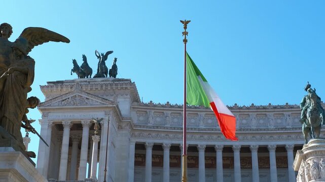 Italian flag waving at altar of the fatherland in rome. National italian flag gently waving in the wind with the magnificent altar of the fatherland, also known as victor emmanuel ii national monument