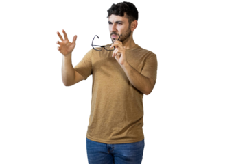 Young man removing glasses expressing disbelief and skepticism on white background. PNG