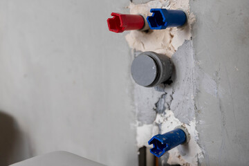 Installation of plumbing and sewer pipes in a prepared wall during home renovation.