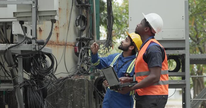 Telecom engineer and technician inspect communication equipment during network maintenance and upgrade operation. Infrastructure inspection, troubleshooting, cable management for reliable connectivity