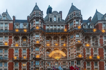 London, UK, The ornate victorian facade of a luxury hotel building is covered with a festive...