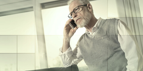 Portrait of senior businessman standing and talking on mobile phone, geometric pattern