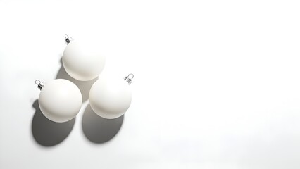 Three Matte White Christmas Baubles Casting Shadows on White