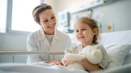 Smiling female nurse in white coat interacts with young girl patient holding teddy bear in hospital bed, showcasing compassionate care and healing environment