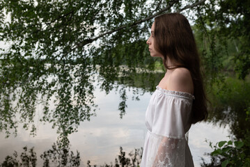 Whispers of Serenity: Woman in White Off-Shoulder Dress by Birch-Lined Lake